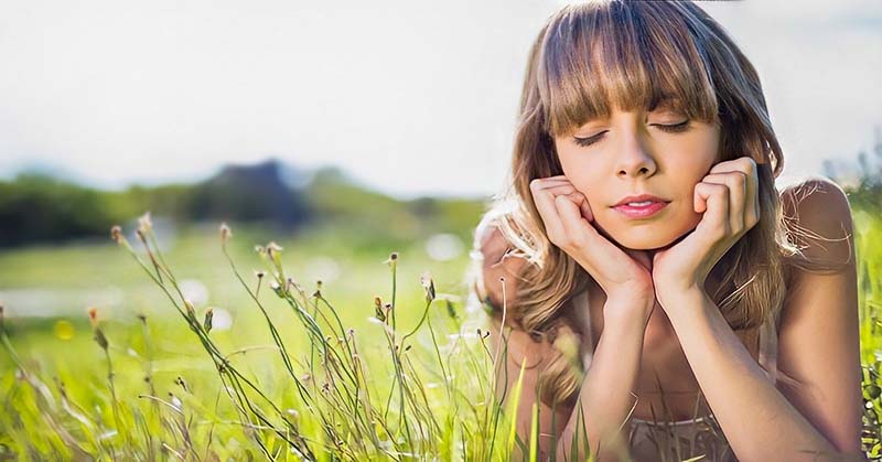 pensive woman on grass living in fear all the time