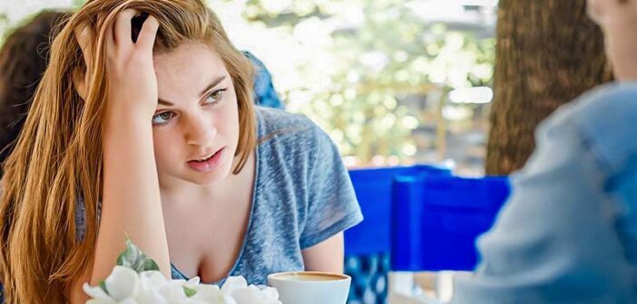 woman looking frustrated with her boyfriend at a cafe - illustrating a love-hate relationship