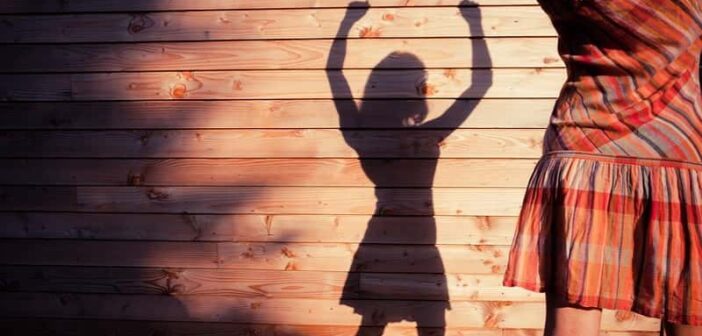 woman casting shadow with raised arms to signify changing her life