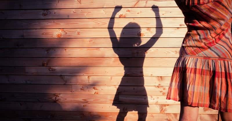 woman casting shadow with raised arms to signify changing her life
