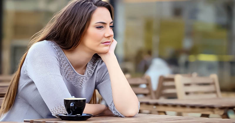 despondent woman sitting with coffee because she is making too many sacrifices in her relationship