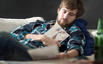 man looking longingly at photos of his ex because he still loves her