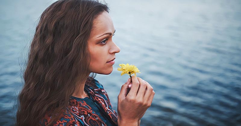 young woman smelling flower but she can't enjoy it or anything