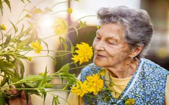 wise elderly woman smelling a flower - illustrating good advice for life