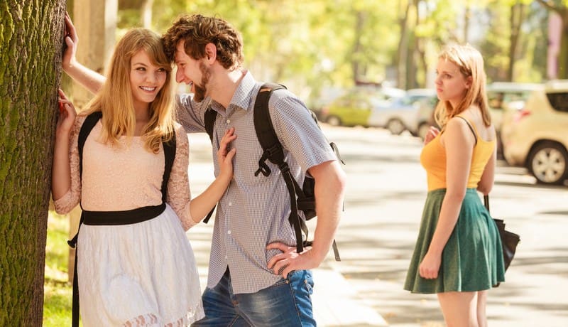 jealous woman looking at loving couple