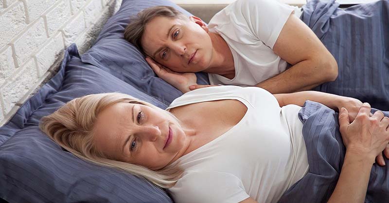 dissatisfied couple in bed who are no longer attracted to each other