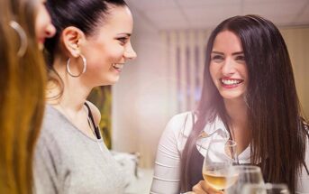 young woman being more outgoing and striking a conversation with two other women