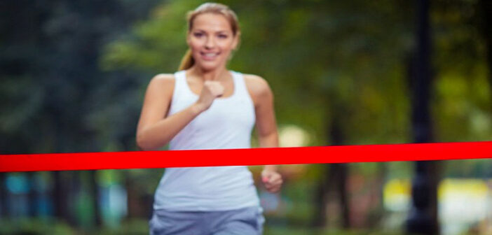 young woman running toward finish line - illustrating finishing what you started