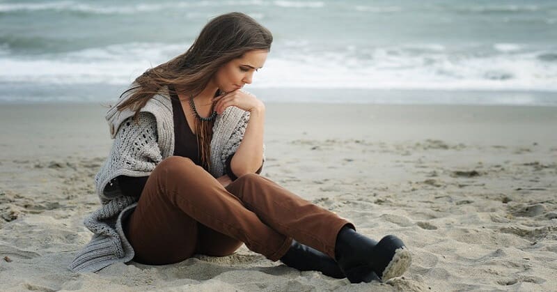 worried young woman sitting on a beach wondering how to fix her life