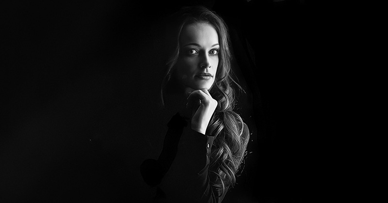 young woman against black backdrop