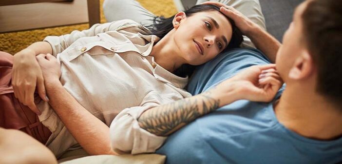 serial monogamist woman lying with head on lap of her boyfriend