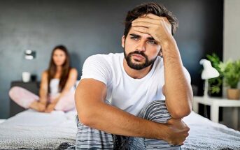 man and woman sitting on bed unhappy - illustrating sexual incompatibility