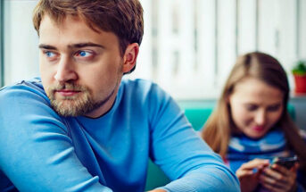 man looking off with girlfriend in the background