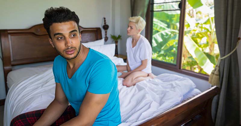 couple looking distant whilst sitting in bed illustrating not liking physical touch