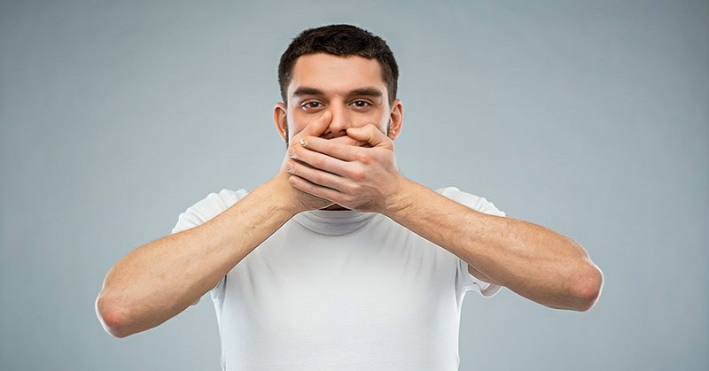 man with hands over his mouth illustrating not interrupting people