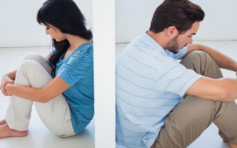 couple sat facing away from each other separated by a wall - illustrating emotional walls