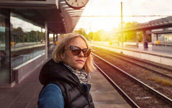 independent woman standing on train station platform