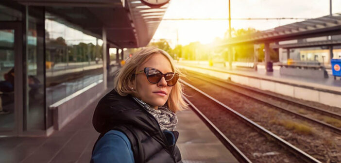 independent woman standing on train station platform