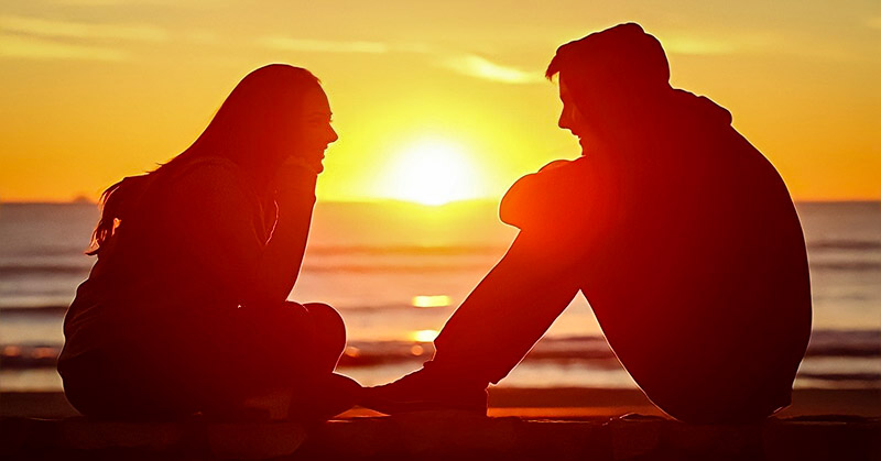 boy and girl talking with sunset in background - illustrating a guy opening up
