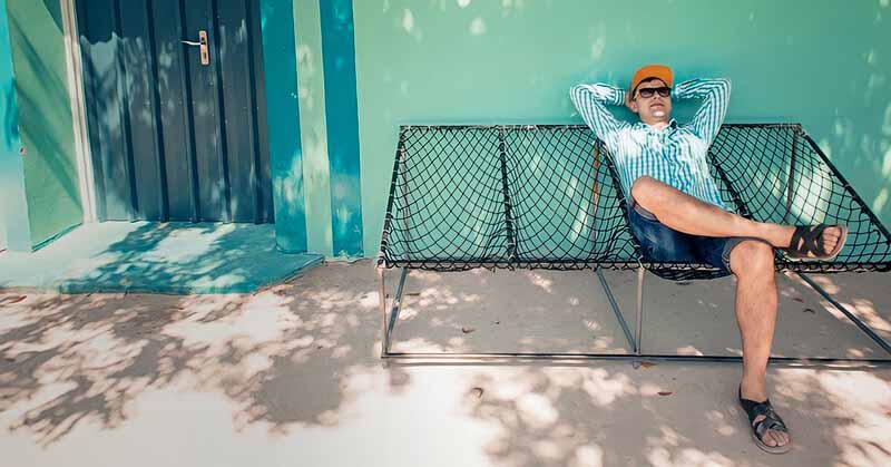 lazy man sitting outside house