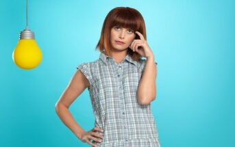 woman with thinking face and pose next to lightbulb