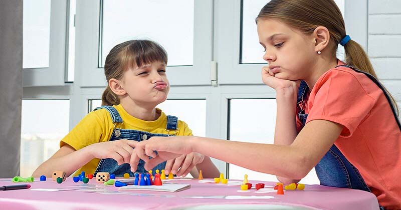 sore loser child making face at sibling