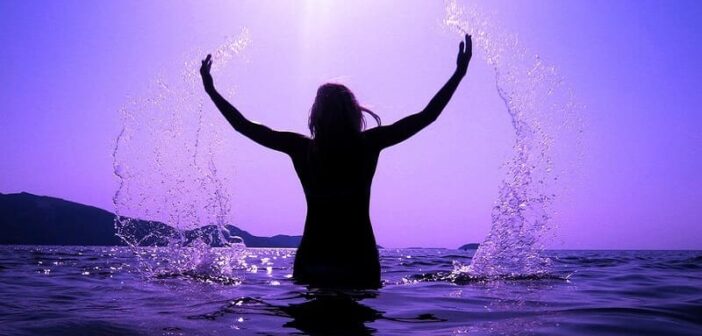 woman splashing in sea - illustrating valuing yourself