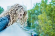 woman whose dreams have been crushed looking over a bridge