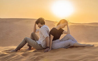 upset couple sitting back to back in desert - illustrating falling for the wrong person