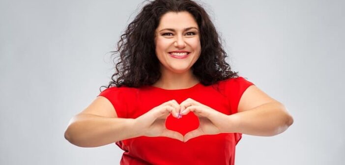 woman wearing a red dress doing the heart sign - illustrating big-hearted people