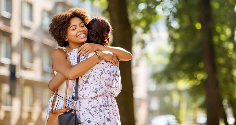 friends hugging in the street