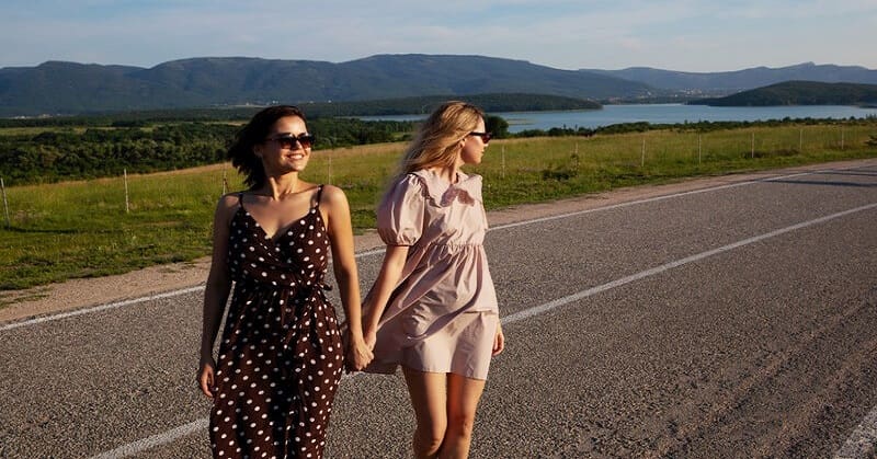 two friends who trust each other walking alone a coastal road