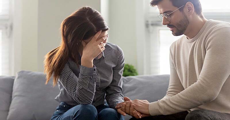 husband holding wife's hand as they try to recover their marriage from his infidelity