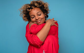 woman hugging herself - illustrating self-care