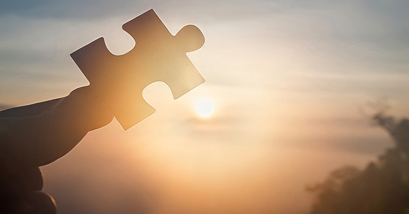 person holding puzzle piece up to the sky - illustrating something missing in your life