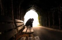 sad person sitting on bench in tunnel - illustrating the fear of losing someone you love