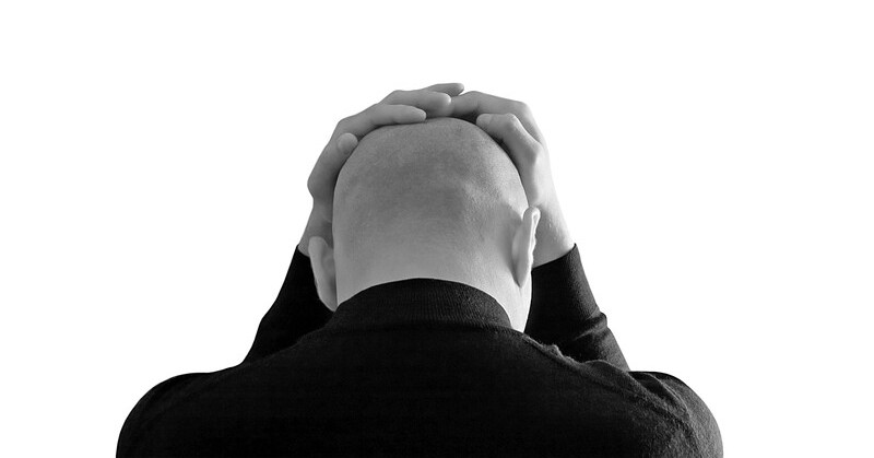 stressed bald man against a white background - illustrating putting pressure on yourself