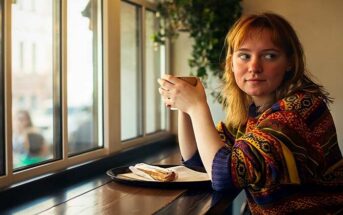 quiet pensive young woman in a cafe - illustrating a sheltered person