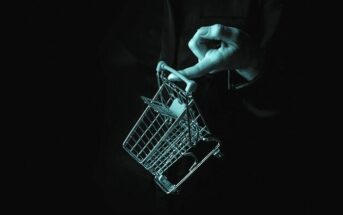 abstract image of a finger holding a small shopping trolley - illustrating being less materialistic