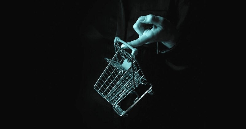 abstract image of a finger holding a small shopping trolley - illustrating being less materialistic