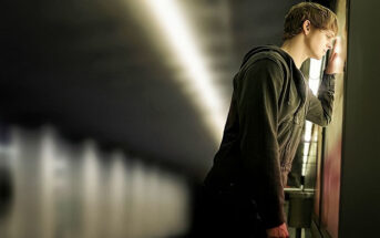 young man standing with his head against a subway wall - illustrating every day feels the same