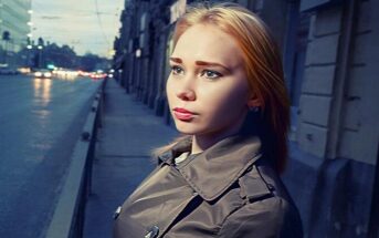 young woman standing on a street looking insecure after being cheated on