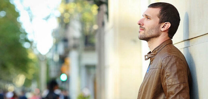 pensive man standing on street who feels life is disappointing