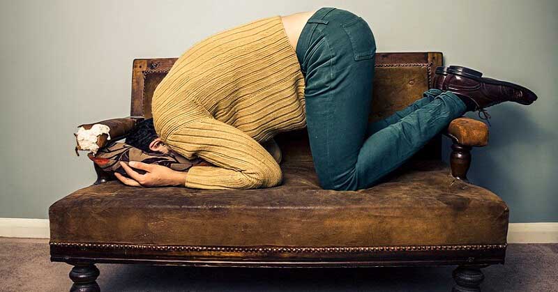 man burying his head in a couch - illustrating being a coward