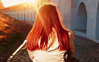 trust the process - red-haired woman walking along a path away from the camera