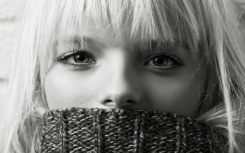 can anxiety cause physical symptoms - woman with sweater pulled up over her mouth