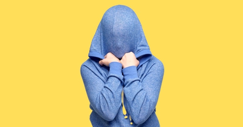 how to be okay - person in blue hoodie pulling hood down over their face