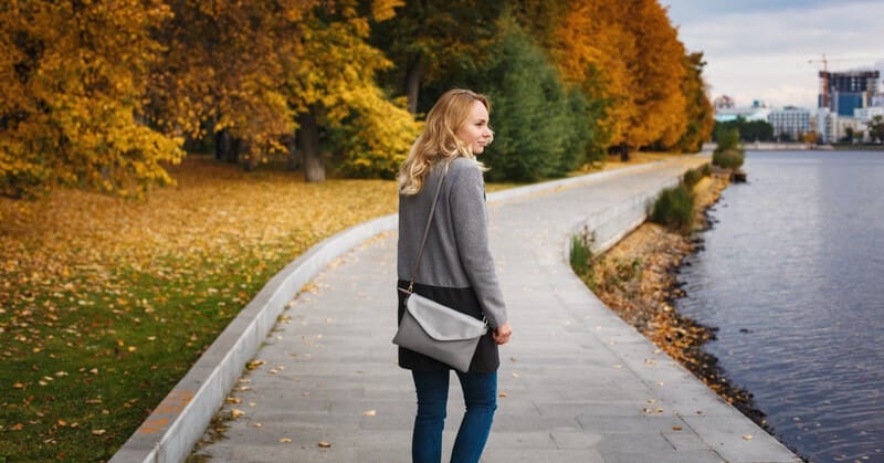 single by choice - woman waling alone alone riverside path