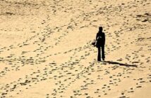 how to find yourself again when lost - silhouette of person walking alone on a sandy beach
