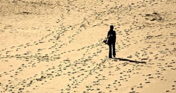 how to find yourself again when lost - silhouette of person walking alone on a sandy beach